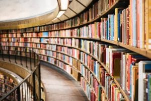 3 things to know before self publishing in Canada - picture of a long curved bookcase in a library